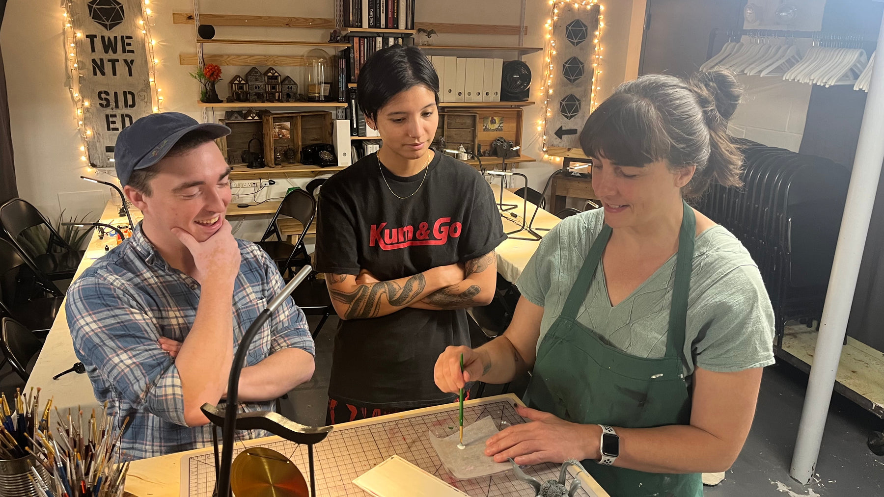 Alex and Sarah look on as Lauren demonstrates mini painting