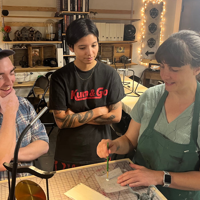 Alex and Sarah look on as Lauren demonstrates mini painting